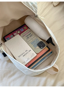 Detail view of the spacious inner compartment of the beige star pattern backpack for students