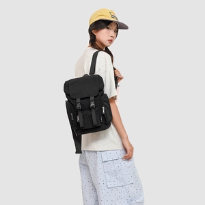 Side view of black canvas workwear backpack on model featuring buckle straps and pockets