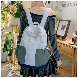 Detail of contrast color nylon backpack with drawstring side and padded shoulder straps