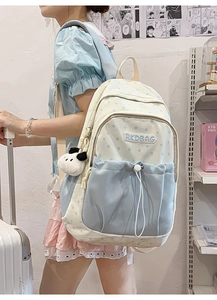 Detail of cream and blue star pattern backpack with RKDBAG logo and cow plush pendant