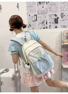 Blue and cream collage backpack with star patterns and a panda plush keychain on girl