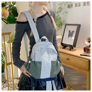 Lifestyle shot of a mini color-block backpack with drawstring side pockets for travel