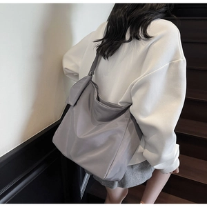 Rear view of a grey nylon hobo bag on a model showing drape and large capacity