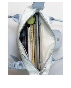 Detailed interior of a large white tote bag showing spacious storage for books and tablet