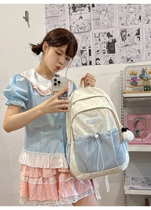 Detail view of beige and blue star pattern backpack with RKDBAG patch and plush charm