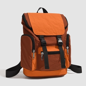 Detail view of brown and orange contrast backpack with nylon fabric and buckle closures