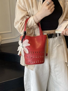 Sac seau rouge ajouré en cuir avec cordon jaune et breloque en forme de marguerite