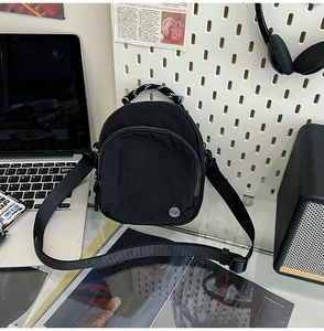 Détail d'un mini sac à dos en nylon noir étanche sur un bureau de bureau moderne