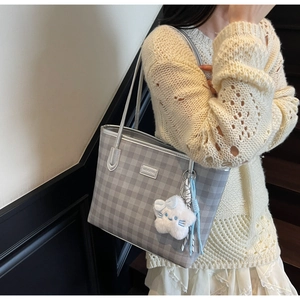 Detail of grey checkered tote bag with a white fluffy cloud charm and silver strap