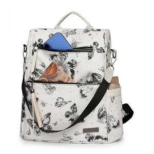 Detail of white butterfly print backpack showing internal storage for phone and bottle