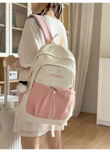 Detail of pink and white star pattern backpack with RKDBAG logo and panda charm