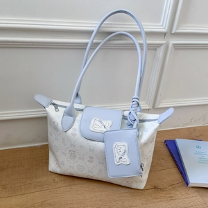 Detail of light blue cartoon tote bag with cat patterns and matching small pouch