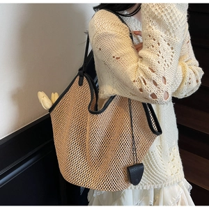 Détail du sac cabas en paille tressée avec bordure en cuir noir et tulipes blanches