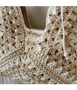 Close-up of beige woven tote bag showing 3D crochet flower texture and white handle