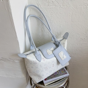 Detail of blue and white patchwork tote bag with cartoon cat print and a small card holder