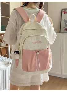 Detail of college style backpack with star pattern and cute plush puppy keychain