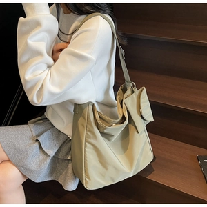 Macro detail of khaki green nylon shoulder bag with side flap pocket and magnetic closure