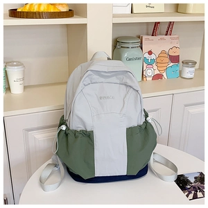 Detailed view of tricolor patchwork backpack with drawstring side pockets on a shelf