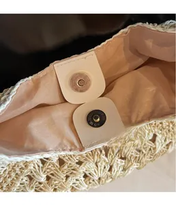 Detail of premium silver magnetic clasp and soft lining on the knit straw beach bag