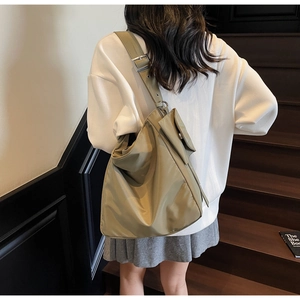 Macro detail of khaki nylon tote bag with metal adjustable buckle and zipper pocket
