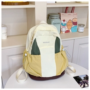 Close-up of color-block nylon backpack featuring drawstring pockets and embroidered logo