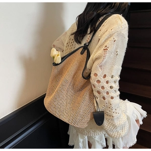 Détail du grand sac cabas en paille avec bordure en cuir noir et texture tissée pour l'été