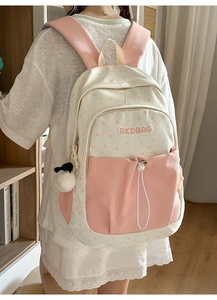Detail of pink and white star pattern canvas backpack with panda plush pendant accessory