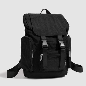 Close-up of black nylon backpack featuring crinkled texture fabric and plastic buckles