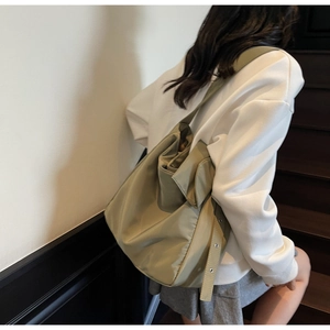 Detail of adjustable wide shoulder strap and side view of olive green nylon tote bag