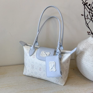 Detail of blue tote bag featuring cat patterns and a small detachable coin purse