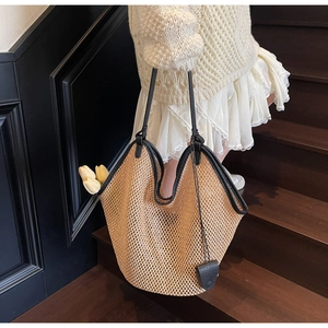 Détail du sac cabas en paille tissée avec bordure en cuir noir et texture