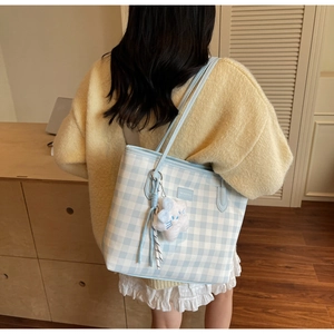 Detail of blue gingham tote bag with long straps and cute fluffy cloud charm on the side