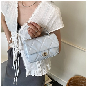 Detail of light blue quilted leather bag with silver chain handle and metal twist lock