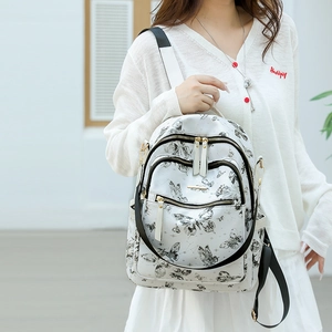 Vue détaillée du sac à dos blanc pour femme avec imprimés papillons noirs et poches