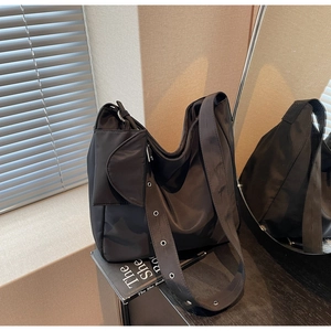 Detail of black nylon hobo bag with wide adjustable eyelet strap and small pouch