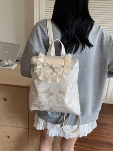 Chic cream-white backpack with butterfly print, ruffle edges, and elegant pearl bow detail