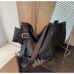 Detail of a black nylon Hobo bag with wide strap, silver buckles and mini side pouch