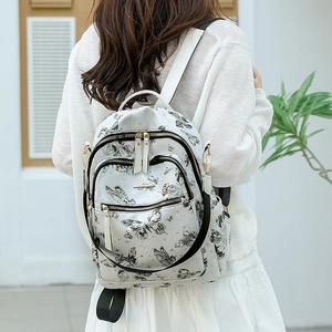 Vue arrière d'un sac à dos blanc chic en similicuir avec imprimé papillon sur modèle