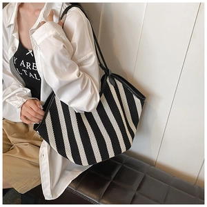 Close-up of woven striped tote bag with breathable mesh texture and long black straps