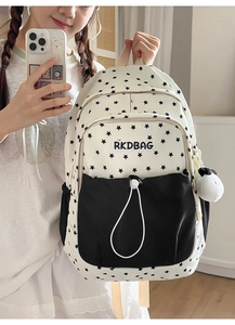 Detail of cream backpack with black star prints and a contrasting black front drawstring pocket
