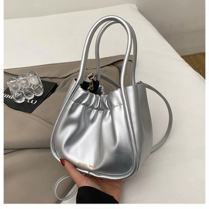 Close-up of silver pleated bucket bag with metallic texture and round top handles