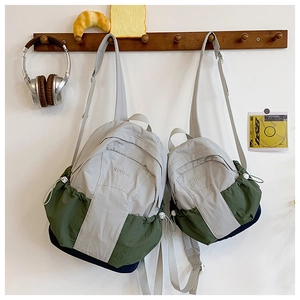 Detail of gray-green nylon casual backpacks in two sizes showing brand embroidery