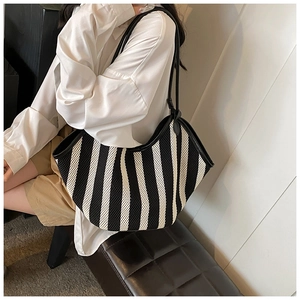Detail of the black and white striped woven mesh tote bag with durable leather handles