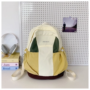 Detail showing colorful patchwork nylon backpack with side drawstring pocket and branding