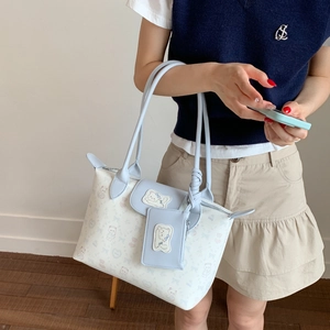 Detail of light blue tote bag featuring cute pink bear prints and a matching small pouch