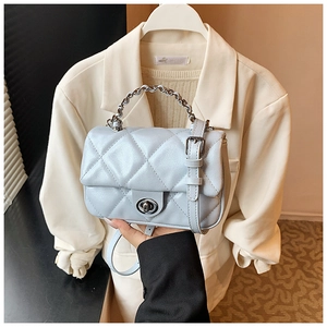 Close-up of light blue quilted leather handbag with silver twist lock and chain strap