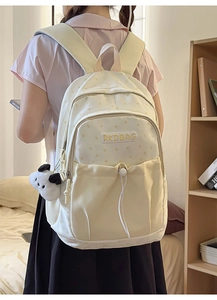 Detail of beige backpack with star patterns and plush charm for student lifestyle