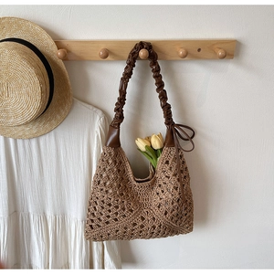 Detail of coffee brown hollow knit shoulder bag with woven texture and leather strap