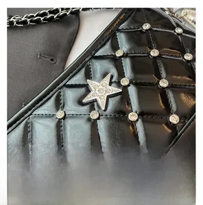Detail of black quilted leather bag with rhinestone studs and silver star hardware