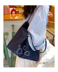 Detail of dark blue denim tote bag with white ho embroidery and contrast stitching